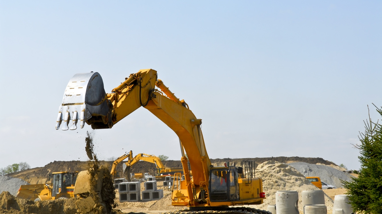 Yellow bulldozer machines digging and moving earth at construction site